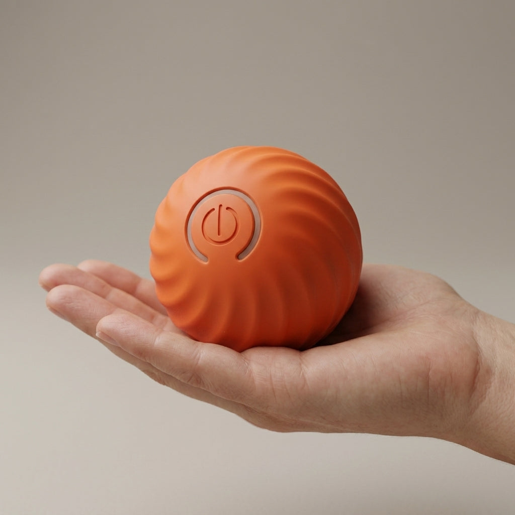 Orange Rollo dog ball held in an adult hand, showing it is about 5cm across