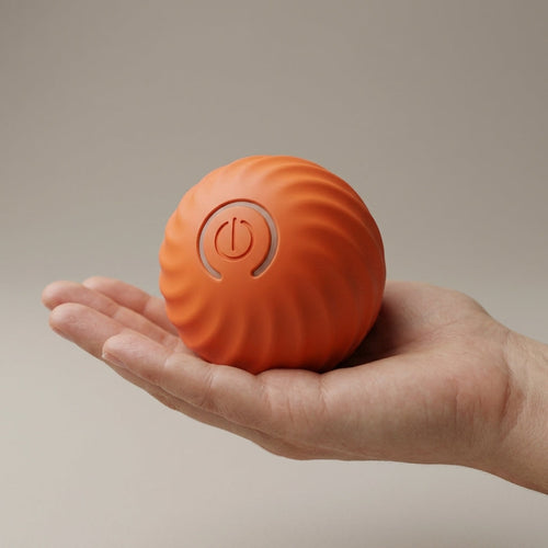 Orange Rollo dog ball held in an adult hand, showing it is about 5cm across